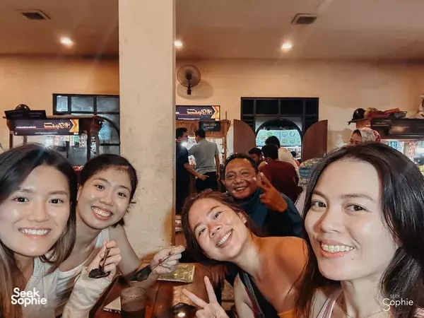 Friends smiling over a casual meal indoors during a 10-hr private car and driver hire in Yogyakarta
