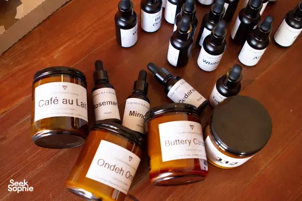 Amber candle jars and fragrance bottles on a wooden table for a Singapore candle workshop by Vcube Scenting