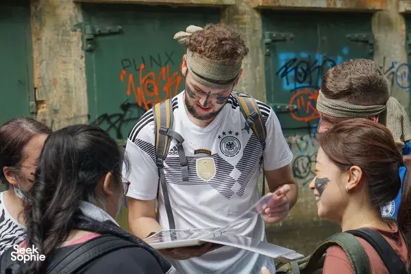 Team members listening as a guide shares clues and points at a map during Fort Serapong’s discovery quest in Singapore