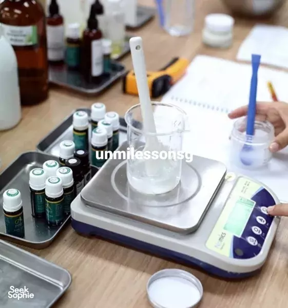 Measuring skincare ingredients in small beakers on a digital scale during Unmi Lessons’ Korean collagen workshop in Singapore