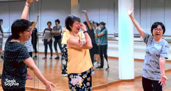 In a Singapore hall, participants practising clown movements as others mirror the game for shared team bonding activities Singapore