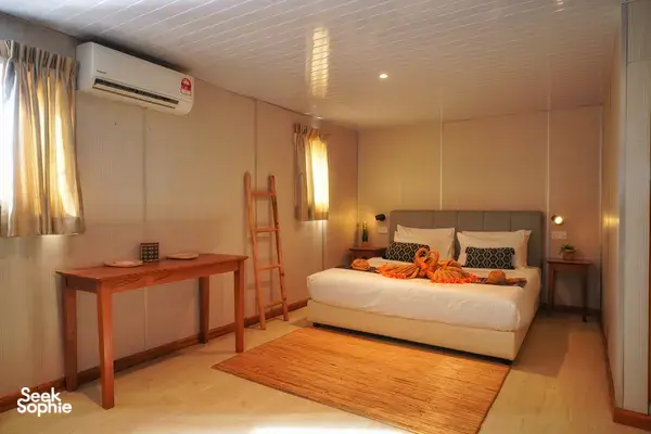 Seaventures Dive Rig cabin bedroom with air-conditioning, a double bed and folded towels for a 4D3N offshore rig stay