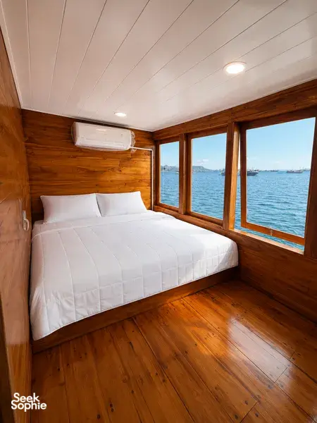 Newest wooden phinisi cabin with a double bed and sea view on a 3D2N shared Komodo cruise, Labuan Bajo