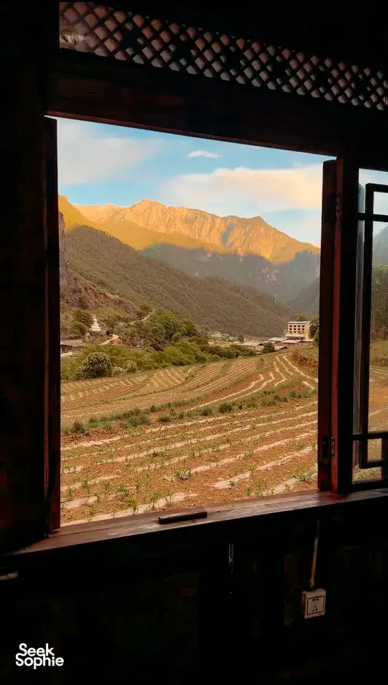 View of mountain range and terraced fields in Shangri-La seen from a room during a 6-day Tibetan guide trek