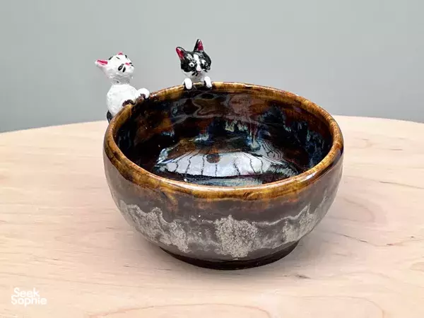 Two animal figurines perched on a speckled glazed ceramic bowl on Emily’s studio table in Tiong Bahru, Singapore—workshops in Singapore