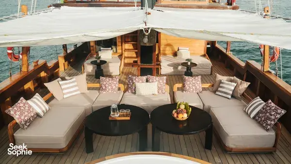 Angelica Liveaboard sundeck lounge with cushioned seating and dining tables on a 3D2N luxe Komodo cruise in Labuan Bajo