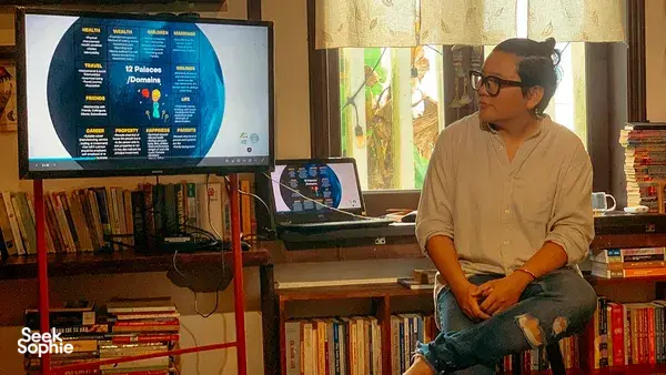 Host at Chan Dat Living Room, Hoi An, presenting a chart on a TV screen during a Vietnamese tradition workshop