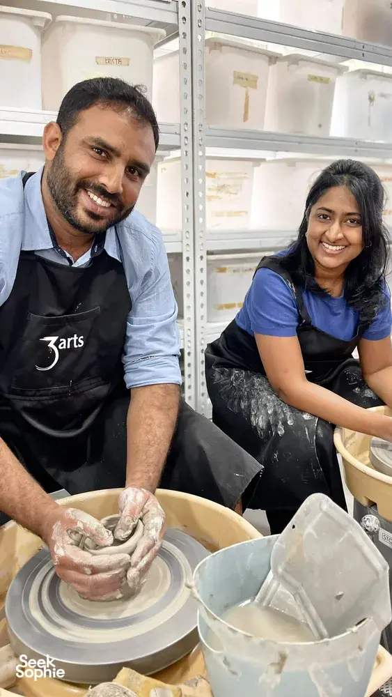 3Arts Pottery host-led pottery wheel lesson in Singapore: two students shaping clay on the wheel — workshops in Singapore