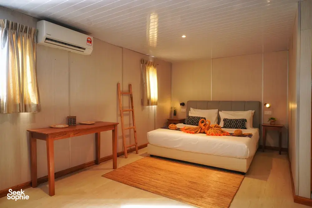 Seaventures Dive Rig cabin bedroom with air-conditioning, a double bed and folded towels for a 4D3N offshore rig stay