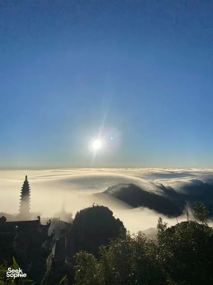 Sunrise with sun flare over a sea of clouds and mountain ridges from Sapaâs Fansipan region, Mt Fansipan