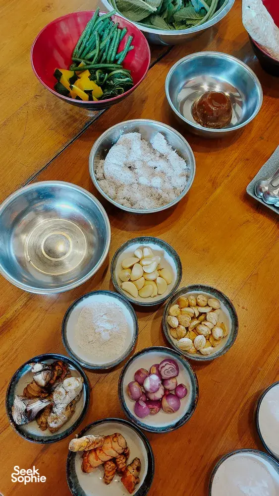 Bowls of fresh vegetables, spices and garlic laid out for Traditional Manggarai vegan cooking at The Kitchen Garden Bajo, Labuan Bajo