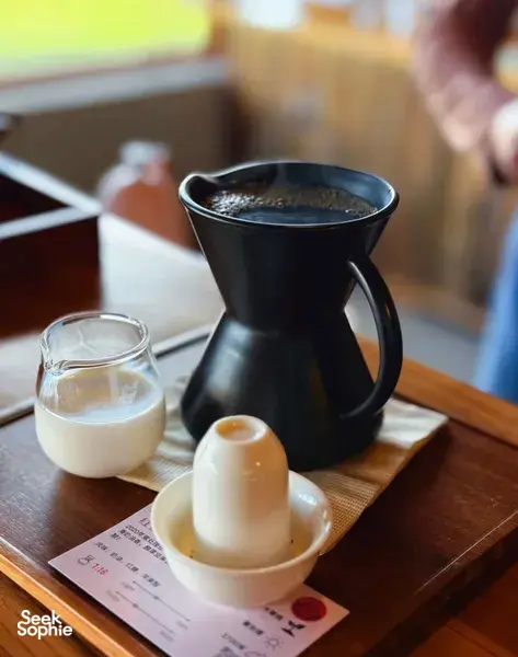 Black pour-over coffee setup with small glass tasting cups on a tray at Seeker Yunnan Coffee Estate workshop in Lijiang