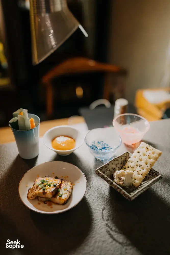Close-up of a Singapore sake tasting table with small appetiser plates, dipping sauces and chilled cups of sake—SakeMama