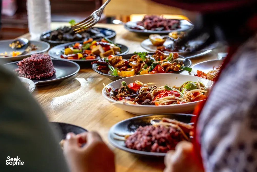 Forage-to-table feast at a Mae Kampong cooking class in Chiang Mai, with colourful plated dishes laid out on a wooden table