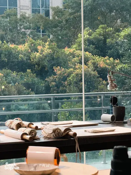Worktable with pottery clay slabs, rolling tools and a cup by the window in Ina Atelier workshops in Singapore