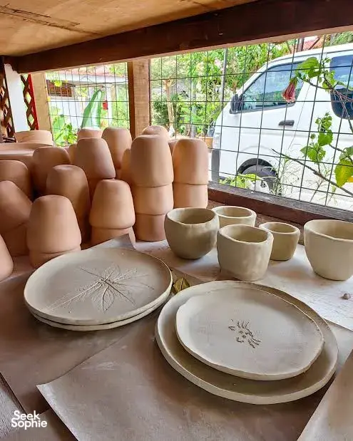 Unpainted ceramic bowls and plates with leaf motifs arranged on a studio table at Ilham Ceramic in Langkawi.