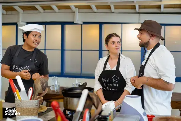 Cooking class on Gili T, Lombok: Gili Cooking Classes hosts explain Indonesian cooking to a small group in aprons