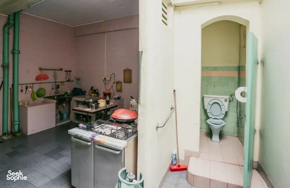 Dapur terbengkalai dengan kompor tua dan pintu menuju toilet, dalam pengalaman Hidden Heritage Behind Jalan Besar’s Doors tentang sudut tersembunyi Singapura