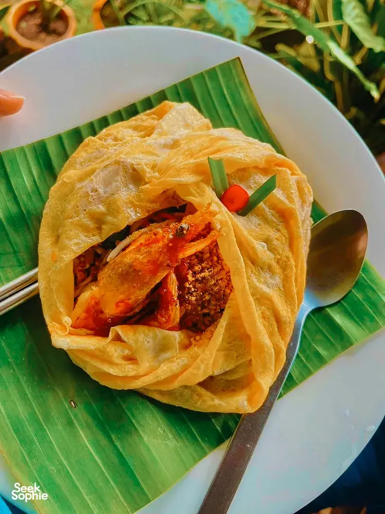 Crispy Thai seafood parcels wrapped in dough, served on a banana-leaf lined plate during a Khao Lak community meal