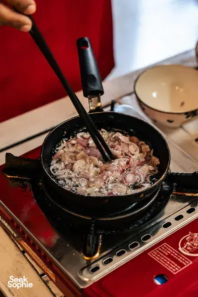 会安 Jolie 烹饪课：便携炉上，平底锅里洋葱和肉滋滋作响，客人们动手制作越南家常菜