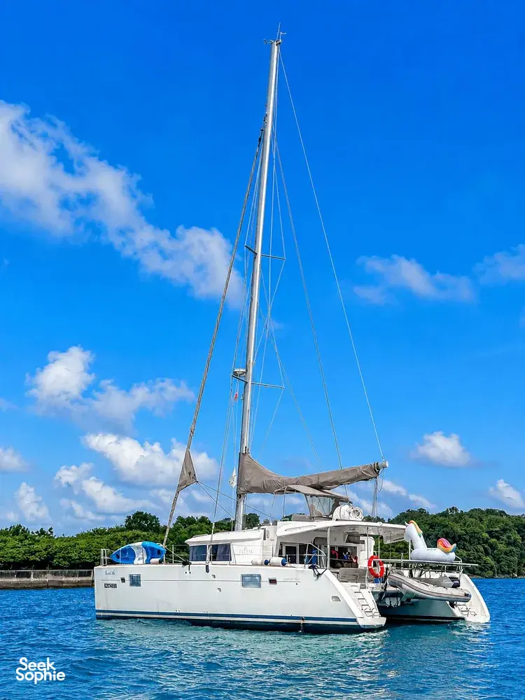 Zen Sea catamaran sailing on the calm waters off Singapore, with bright blue sails under a clear sky
