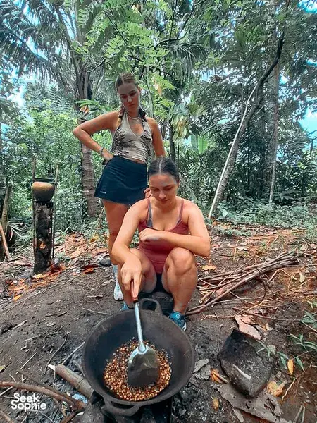 Outdoor forest cooking with the Lombok Forest Tour on a former loggers walk, stirring a black pot over the fire