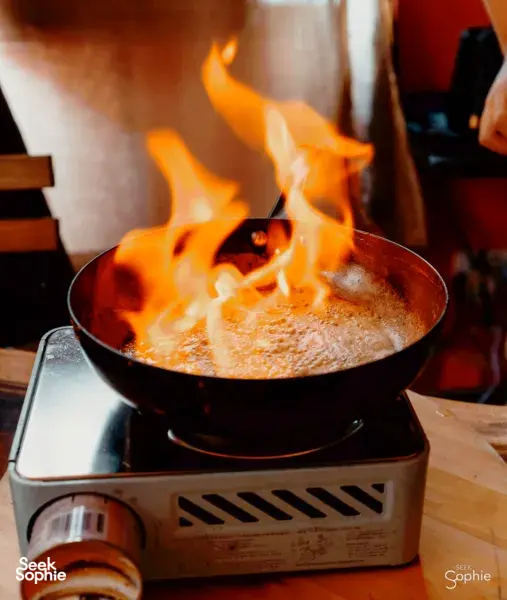 Honey mixture bubbling in a black pan over an open-flame stove during a Singapore honey ice cream workshop—workshops in Singapore