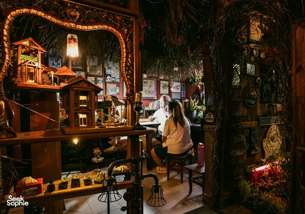 Ruang dalaman yang hangat dengan rak hiasan dan tumbuhan di sisi kaunter, untuk kisah apartmen sewa Hidden Heritage dan permata tersembunyi Singapura