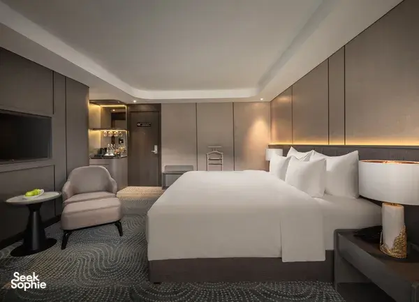 Doris Cruise cabin with king-size bed, sofa chair and bedside lighting on a 2D1N Lan Ha Bay cruise in Vietnam