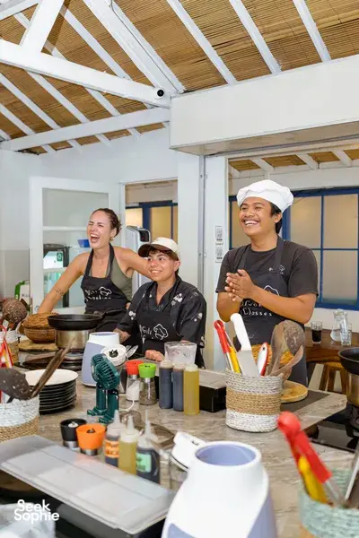 Local guide-hosted Indonesian cooking class on Gili T in Lombok, students in aprons preparing food in a bright kitchen