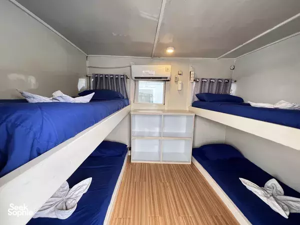 View of an onboard cabin with two-tier blue bunks and open storage, ready for travellers on a La Famille 3D2N cruise from Labuan Bajo