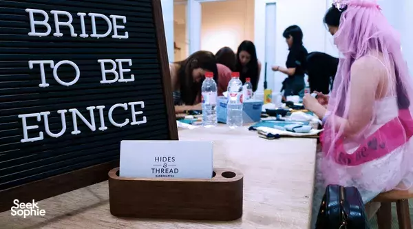 Event table at Hides and Thread in Singapore with a “Bride to be” sign, bottles and stationery during workshops in Singapore