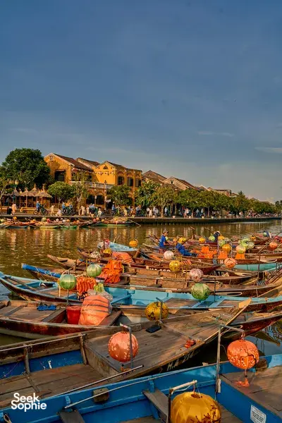 Sunset paddle in Hoi An from a traditional boat on the river, passing the Ancient Town’s riverside buildings with Hoi An Kayak Tour