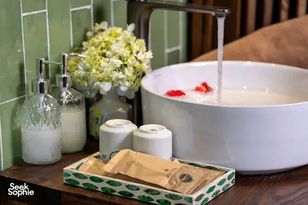 Toiletries and a white bath basin on a wooden table in Cat Ba Ocean Cruises’ cabin for the 3D2N Cat Ba cruise