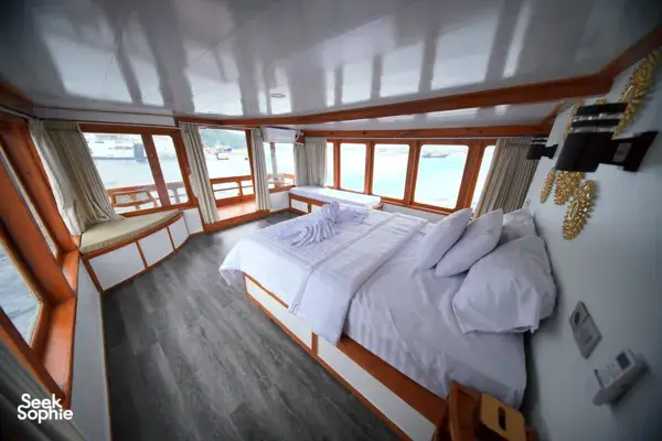 Twin beds in a wood-panelled cabin on a boat for a 3D2N join-in Komodo trip from Labuan Bajo to Komodo Island