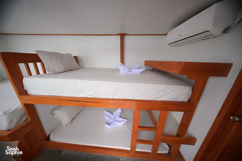 Travass Life 3D2N join-in Komodo trip bunk cabin with ladder, air conditioner and folded towels on the beds, Labuan Bajo