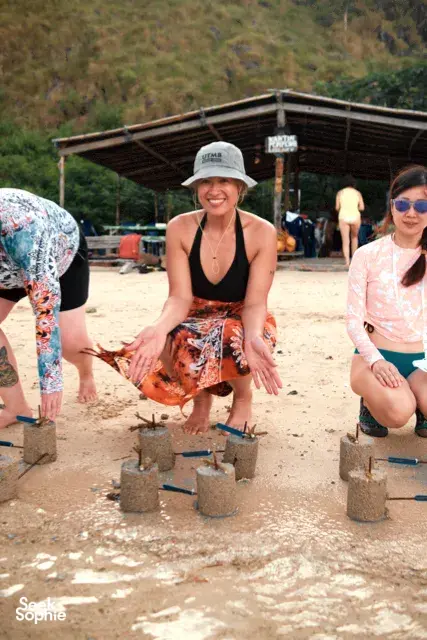Volunteers placing coral fragments into cement plugs in a nursery area during the Rinca Coral Nursery Programme, Komodo Island