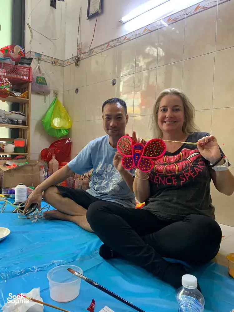 Workshop guests holding red lantern decorations at Viet Awesome Tours’ Saigon craft alley workshop in Ho Chi Minh City