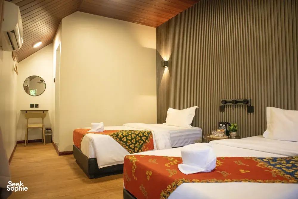 Triple-bed room at Sukau Greenview Lodge for a Kinabatangan River safari night, with neatly laid linens and pillows