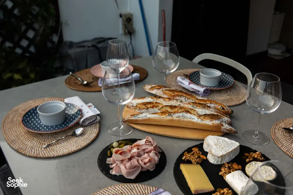Loft dining table set with French baguettes, cheese and cured meats beside wine glasses in Singapore for private dining Singapore