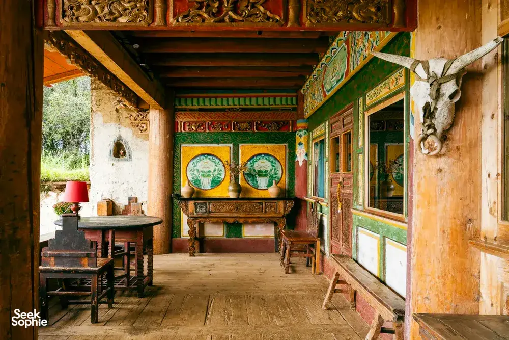 Traditional Tibetan-style dining room with carved furniture and colourful murals at a Mission Liotard base near Shangri-La