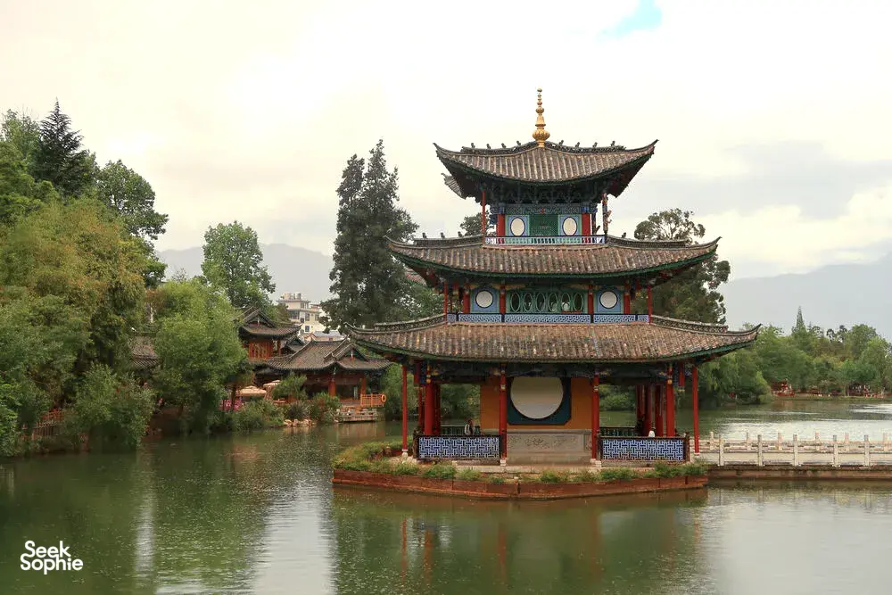 Traditional Naxi pavilion on a small island above a pond, with Naxi-style buildings in Shuhe Ancient Town, Lijiang