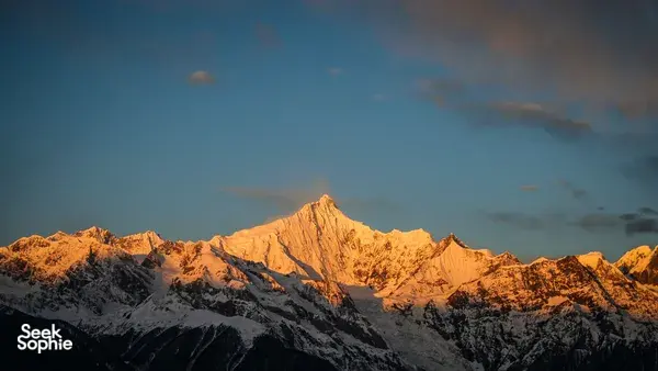 Glowing mountain peaks at sunrise near Shangri-La, capturing the dramatic highland landscape on a 6-day trek loop