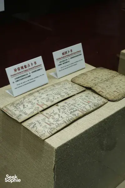 Folded guide maps and printed information cards with Chinese text laid on a table in Lijiang Old Town