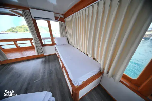 Cabin bed beside the side windows on a boat for a 3D2N join-in Komodo trip departing Labuan Bajo towards Komodo Island