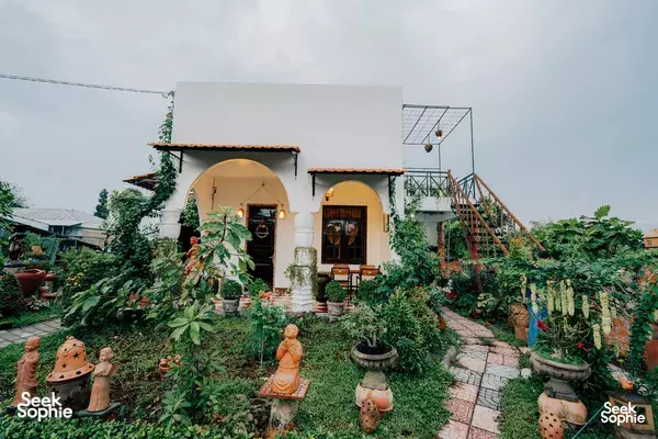 Mekong Pottery Homestay courtyard with a white house, lanterns and terracotta garden ornaments in the Mekong Delta