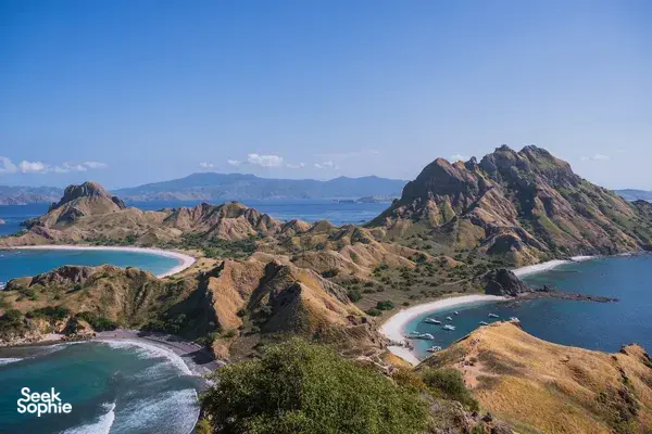 Aerial view of rugged coastlines, sheltered lagoons and sandy beaches from above, showing Komodo cruise scenery near Labuan Bajo