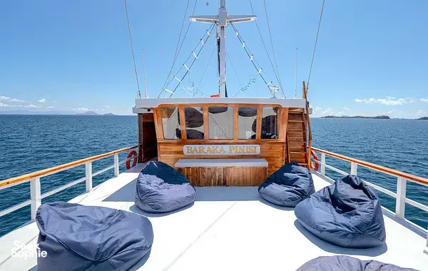 Bow deck of the Baraka Pinisi liveaboard with dive cushions and a sailing mast over open water on the 4D3N Komodo trip, Labuan Bajo