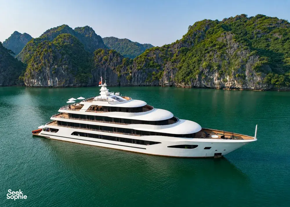 White Oasis Bay Party Cruiser sailing through Halong Bay with limestone karsts rising from turquoise water
