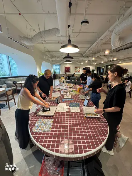 Team workshop in Singapore with Agrihome: participants cutting reusable food-wrap sheets at a long table for team building Singapore